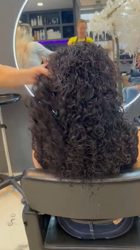 Textura cacheada escura em movimento, num trabalho da Loja do Cabelo.