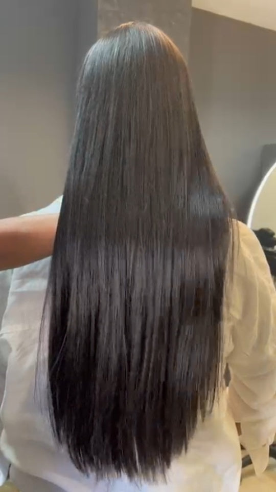 Cabelo escuro comprido e liso, visto de costas, num trabalho da Loja do Cabelo.