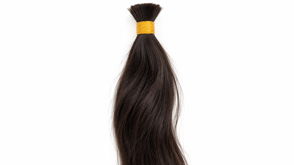 Composição editorial de um lote de cabelo solto escuro, com detalhe das fibras e da raiz atada.